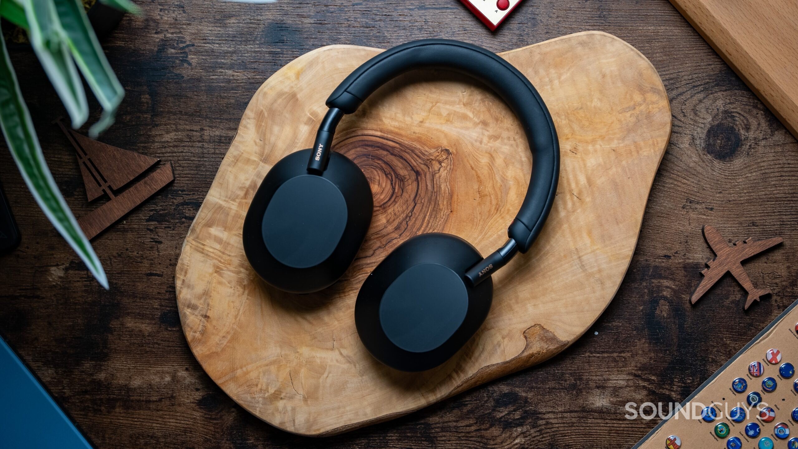 Sony WH 1000XM5 headphones laying flat on wooden table. Sony WH 1000XM5 headphones laying flat on wooden table.